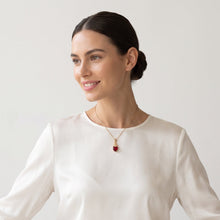 Cargar imagen en el visor de la galería, Modelo luciendo dije Llena de Gracia de Sagrado Corazón en cristal rojo y enchapado en oro 18k con cadena de balines