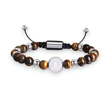 Cargar imagen en el visor de la galería, Pulsera Llena de Gracia con piedras naturales marrones, balines de acero quirúrgico y dije de San Benito en plata.