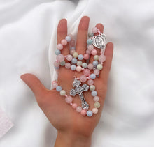 Cargar imagen en el visor de la galería, Rosario católico Llena de Gracia con cuentas de porcelana acrílica en tonos pastel y crucifijo plateado en una mano.