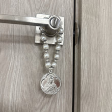 Cargar imagen en el visor de la galería, Bendición de hogar Llena de Gracia con perlas beige y medallón de rodio de Jesús y María colgada en una puerta
