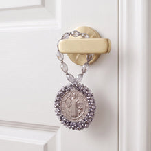 Cargar imagen en el visor de la galería, Bendición de hogar Llena de Gracia con medalla de San Benito en plata y cristales colgando de una manija de puerta
