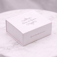 Cargar imagen en el visor de la galería, Caja de regalo blanca con el logo de Llena de Gracia sobre una superficie de mármol para joyería
