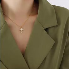 Load image into Gallery viewer, Collar Llena de Gracia con dije de cruz pequeña decorado con perlas naturales y baño de oro 14k sobre blazer verde
