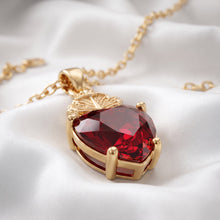 Cargar imagen en el visor de la galería, Collar Llena de Gracia con dije de Sagrado Corazón en cristal rojo y enchapado en oro 18k sobre tela blanca

