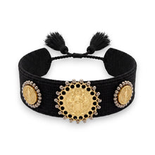 Cargar imagen en el visor de la galería, Pulsera Llena de Gracia tejida en hilo negro con tres dijes de San Benito en baño de oro de 18k y detalles de borlas.
