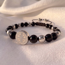 Cargar imagen en el visor de la galería, Pulsera Llena de Gracia de ónix negro y acero quirúrgico con dije de San Benito en plata, diseño ajustable y elegante.
